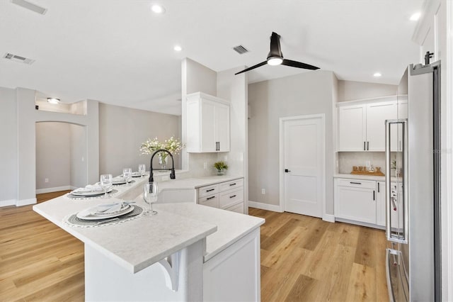 kitchen featuring light hardwood / wood-style flooring, white cabinetry, and backsplash