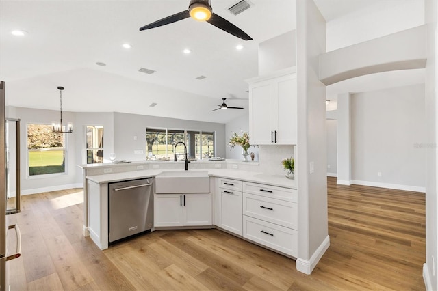 kitchen featuring sink, dishwasher, white cabinetry, and vaulted ceiling