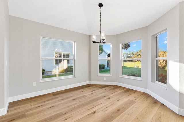 unfurnished dining area featuring a notable chandelier and light hardwood / wood-style floors