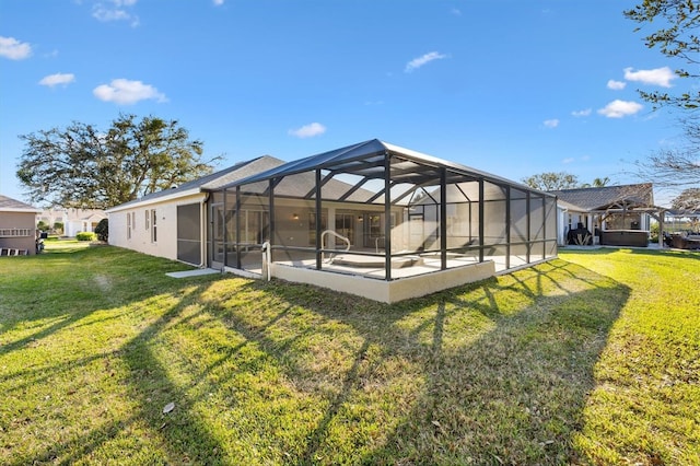 rear view of house with a yard, glass enclosure, and a patio area