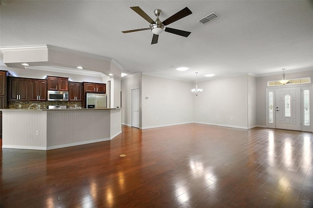 unfurnished living room with dark wood-style floors, crown molding, visible vents, baseboards, and ceiling fan with notable chandelier