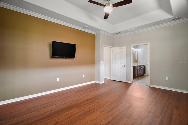 unfurnished bedroom featuring dark wood-style flooring, a raised ceiling, visible vents, and baseboards