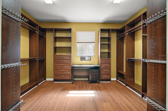 walk in closet featuring wood finished floors and built in study area