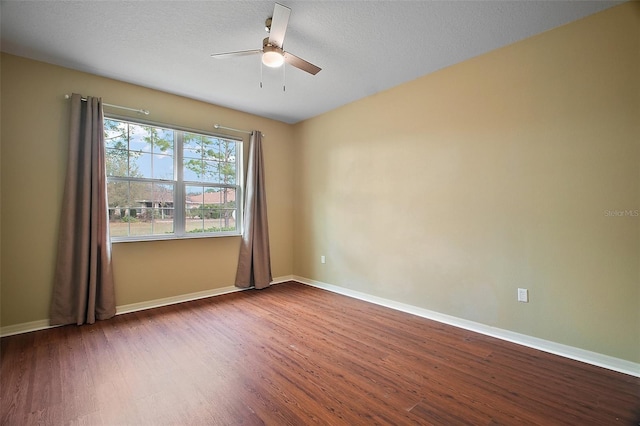 spare room with ceiling fan, a textured ceiling, baseboards, and wood finished floors