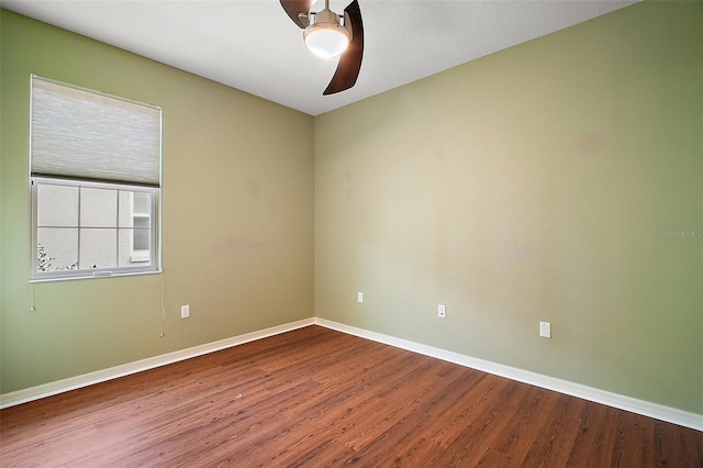 spare room featuring ceiling fan, baseboards, and wood finished floors