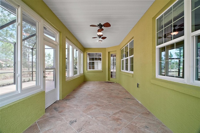 unfurnished sunroom with a wealth of natural light and a ceiling fan