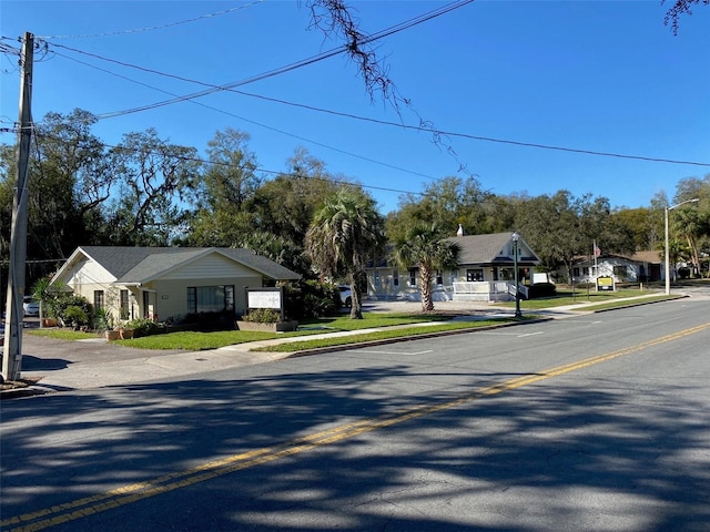 view of road with curbs, street lighting, sidewalks, and a residential view