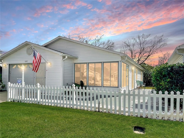 view of front of house with a garage and a lawn