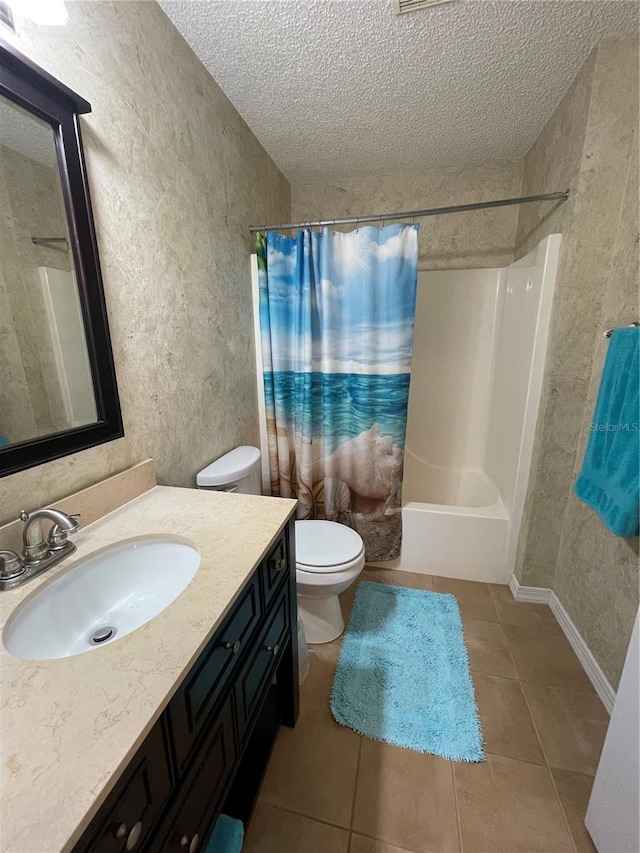 full bathroom with vanity, a textured ceiling, shower / bathtub combination with curtain, tile patterned flooring, and toilet