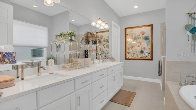 bathroom featuring double vanity, baseboards, tile patterned floors, a sink, and a bath