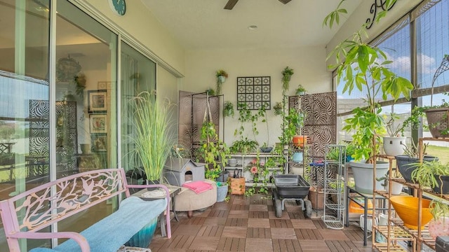 sunroom / solarium featuring a wood stove and ceiling fan