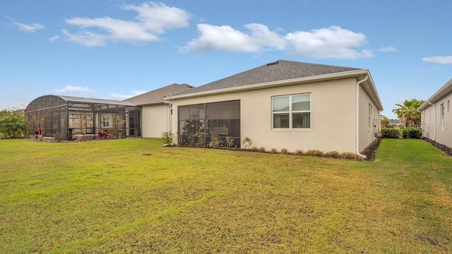 rear view of property featuring a lanai, a yard, and stucco siding