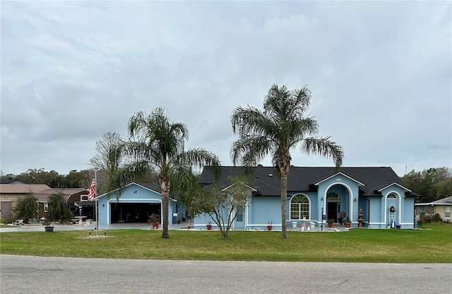 ranch-style house featuring a garage, driveway, and a front lawn