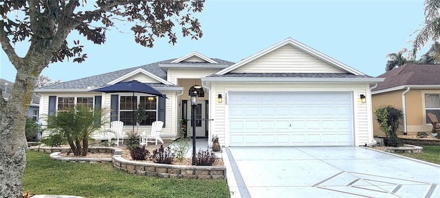 ranch-style home featuring a front lawn, roof with shingles, driveway, and an attached garage