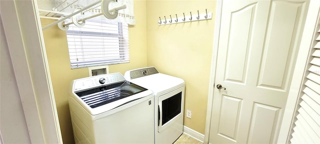 washroom with laundry area, washing machine and clothes dryer, and baseboards