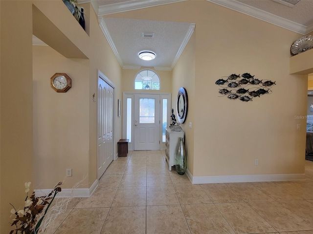 foyer with light tile patterned flooring, a textured ceiling, baseboards, and ornamental molding