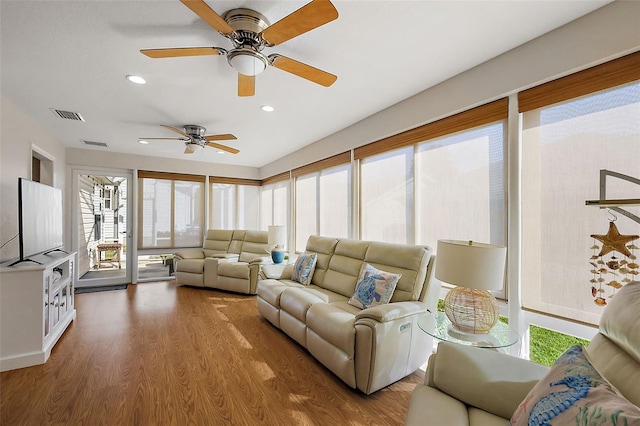 living area with wood finished floors, visible vents, and recessed lighting