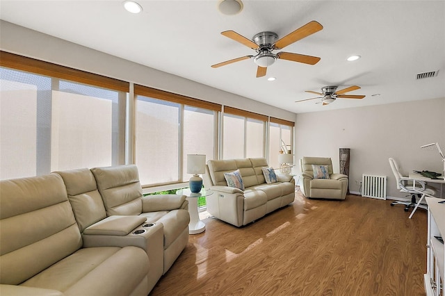 living room with visible vents, wood finished floors, and recessed lighting