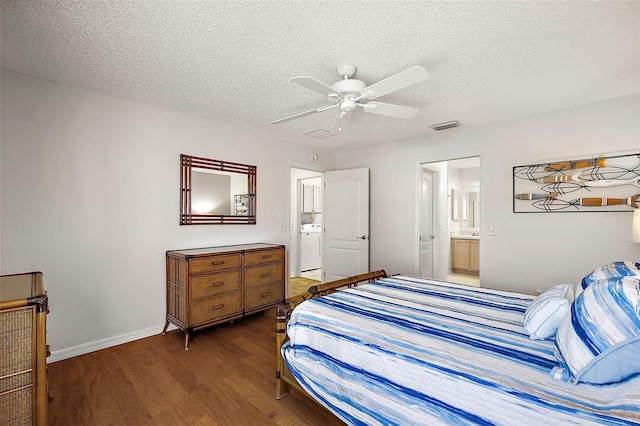 bedroom with visible vents, a textured ceiling, dark wood finished floors, and washer / dryer