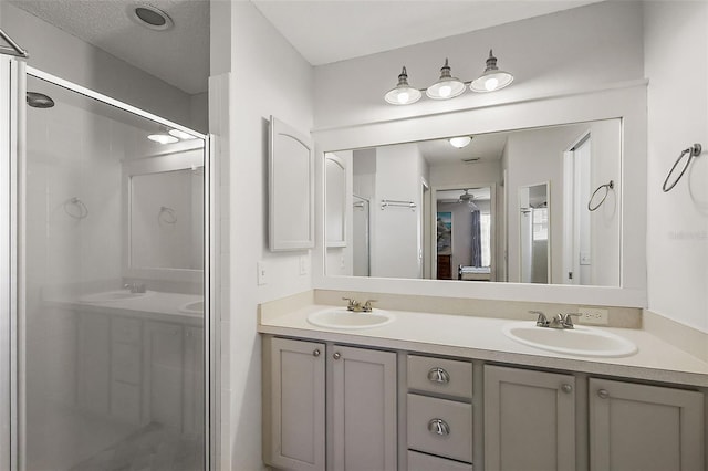 bathroom with double vanity, a stall shower, and a sink