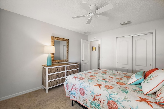 bedroom featuring a textured ceiling, visible vents, baseboards, a closet, and carpet