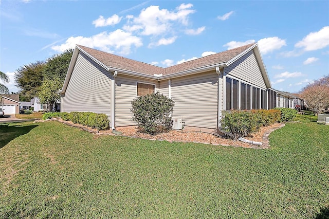 view of side of home featuring central air condition unit and a lawn