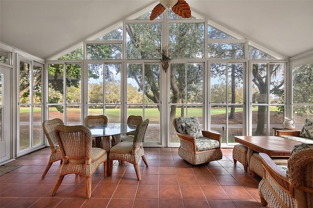 sunroom featuring lofted ceiling, ceiling fan, and a healthy amount of sunlight