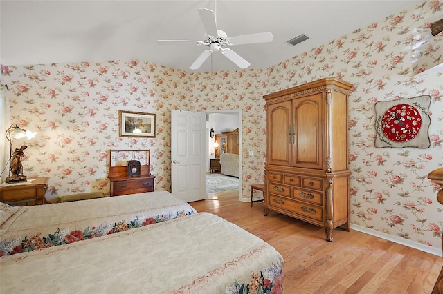 bedroom with wallpapered walls, baseboards, visible vents, ceiling fan, and light wood-type flooring