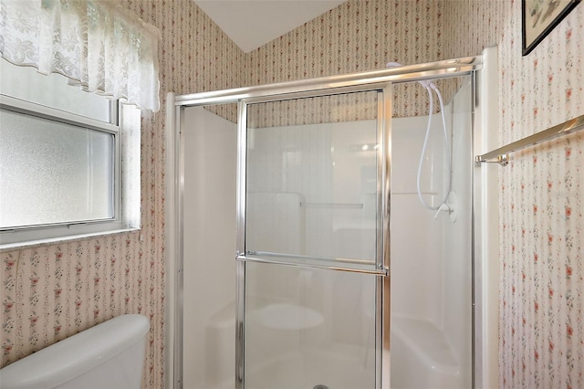 full bathroom featuring a shower stall, toilet, and wallpapered walls