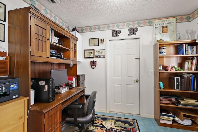 home office featuring a textured ceiling and light tile patterned flooring