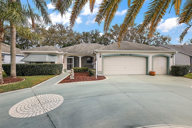 single story home featuring a garage, concrete driveway, and stucco siding