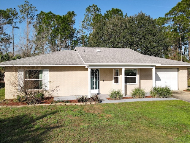 ranch-style house featuring a garage, a front yard, brick siding, and a shingled roof