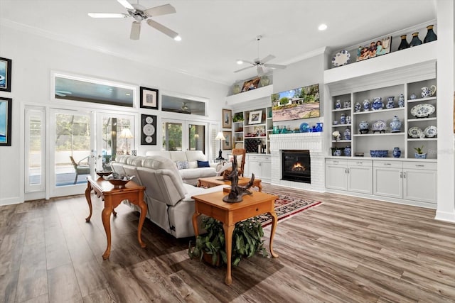 living room featuring a fireplace, wood-type flooring, built in shelves, and french doors