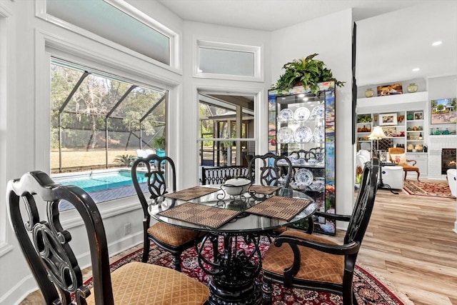 dining space featuring a brick fireplace and light hardwood / wood-style flooring