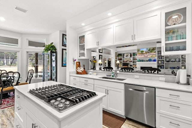 kitchen with sink, white cabinets, stainless steel appliances, and light hardwood / wood-style flooring