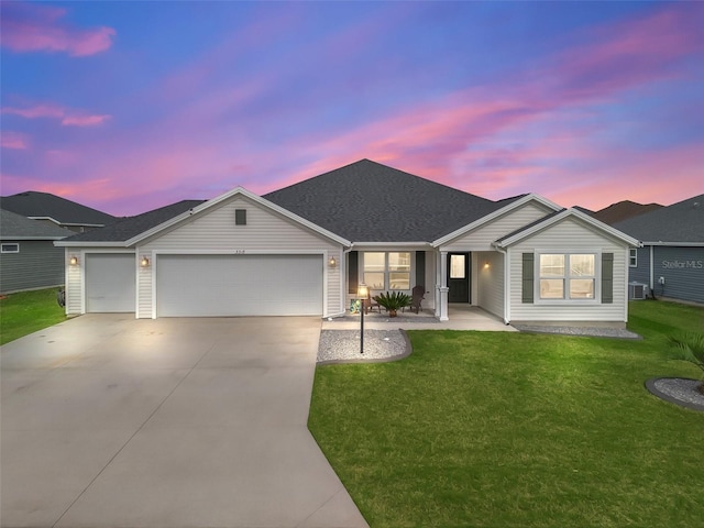 ranch-style house with a yard, a shingled roof, central AC, a garage, and driveway