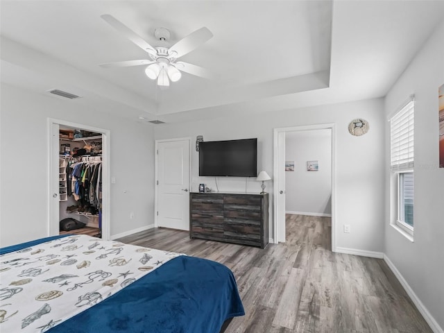 bedroom with visible vents, a tray ceiling, and baseboards