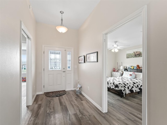 foyer with ceiling fan, baseboards, and wood finished floors