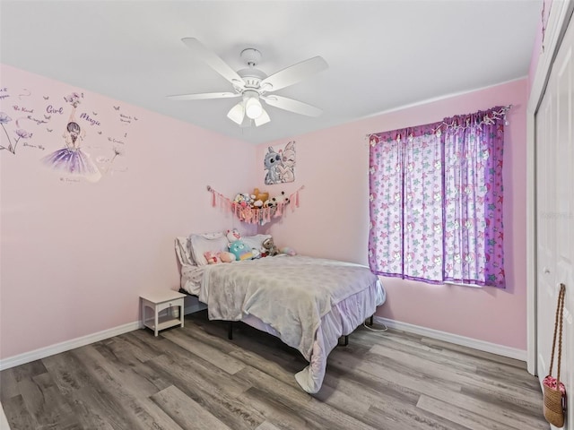 bedroom with a ceiling fan, a closet, baseboards, and wood finished floors