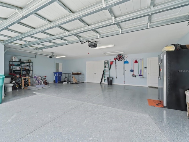 garage with freestanding refrigerator and a garage door opener