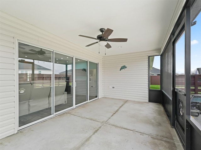 unfurnished sunroom featuring a ceiling fan