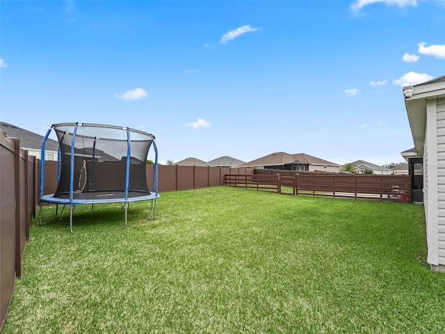 view of yard featuring a fenced backyard and a trampoline