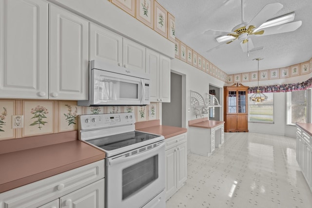 kitchen featuring a textured ceiling, white appliances, and white cabinetry