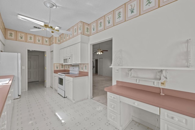 kitchen with white appliances, ceiling fan, and white cabinetry