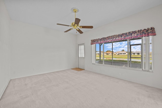 carpeted spare room with a ceiling fan