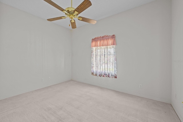 carpeted spare room featuring a ceiling fan