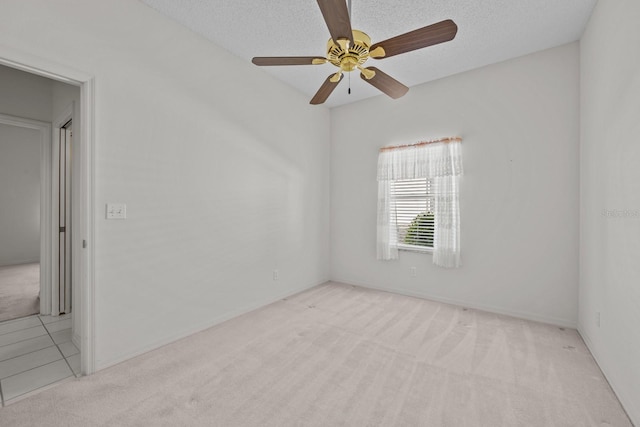 carpeted spare room with a ceiling fan and a textured ceiling