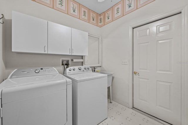 clothes washing area with washing machine and dryer, cabinet space, and baseboards