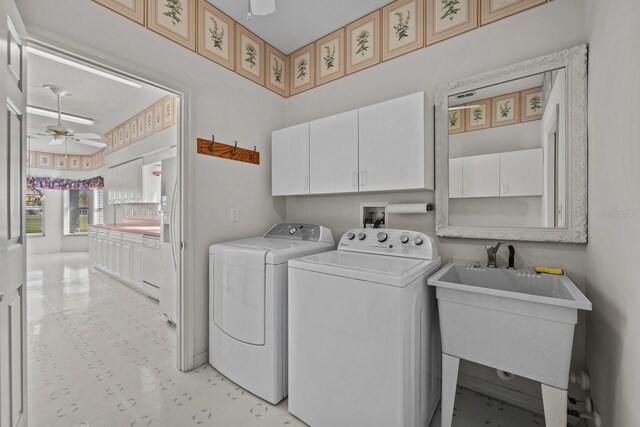 laundry room with a ceiling fan, cabinet space, independent washer and dryer, and a sink