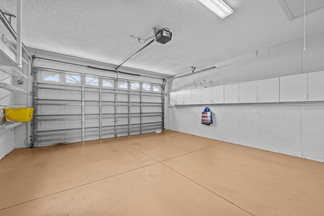 garage with a garage door opener and concrete block wall